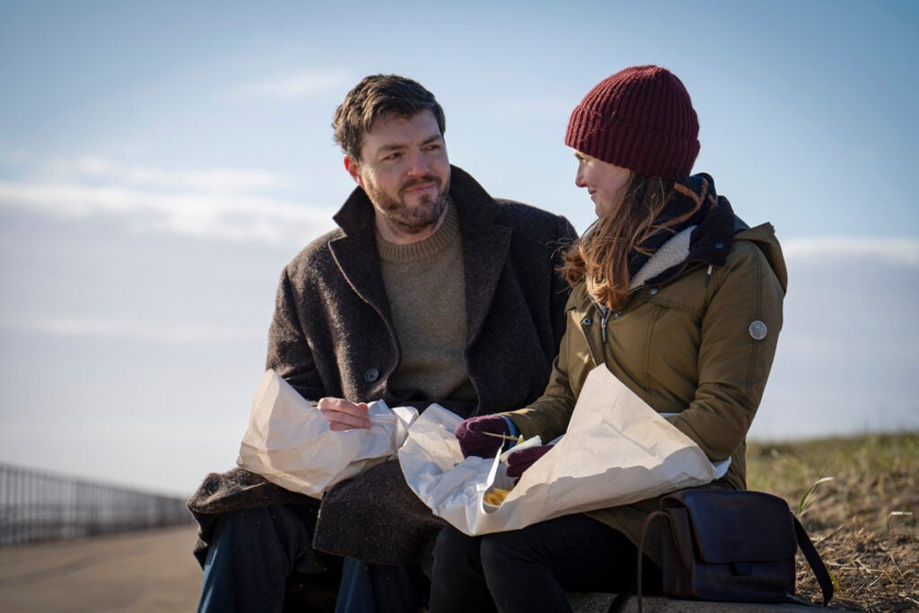 Strike and Robin eating fish and chips